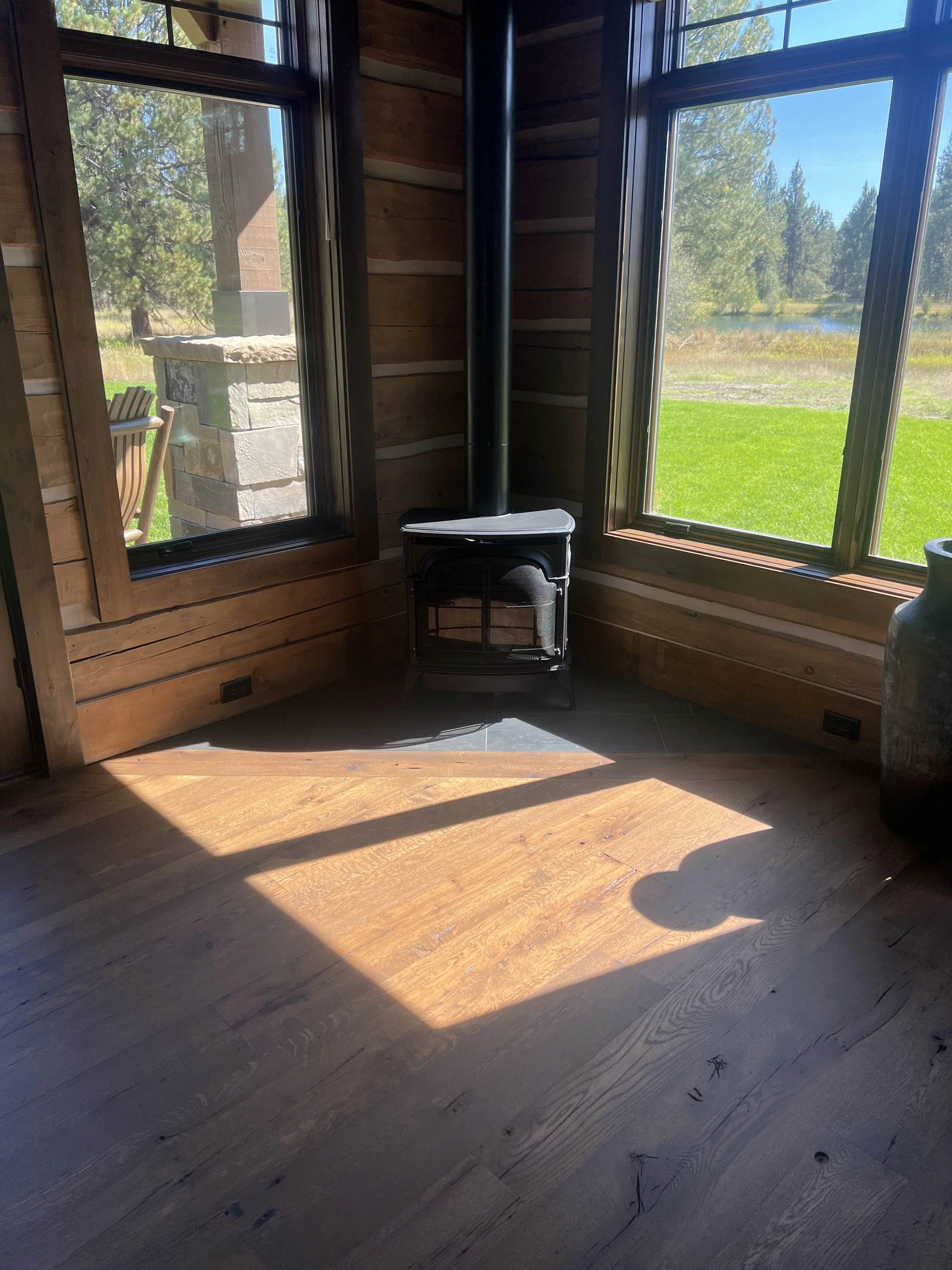Fireplace meeting the hardwood floor in a Missoula custom build by Winnwood Flooring
