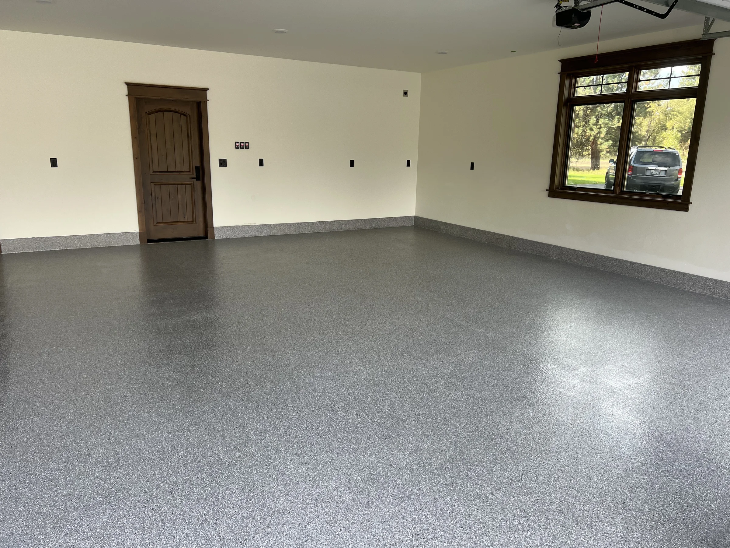 Finished gray flake epoxy garage floor in a Missoula home by Winnwood Resins